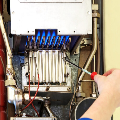 hands of a plumber repairing a gas heating